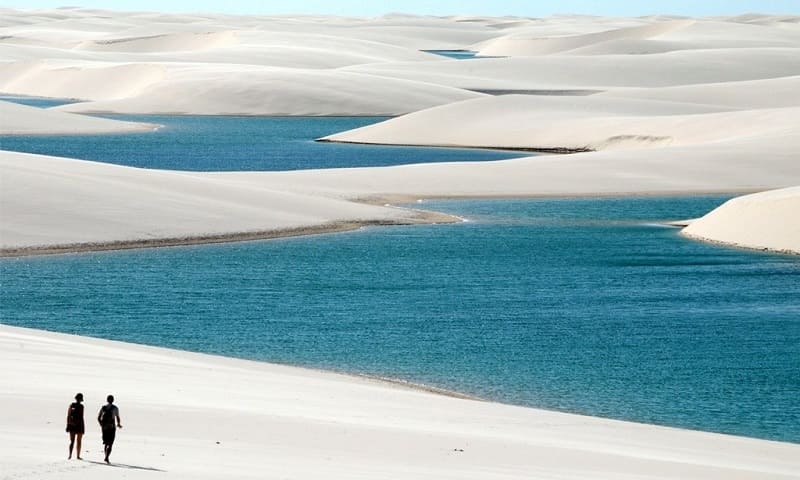 Foto dos lençóis maranhenses, onde aparecem diversas dunas permeadas pela água azul.