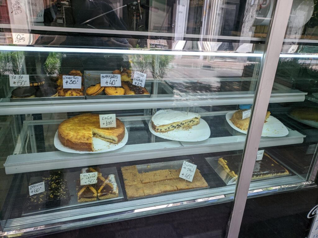 Foto do balcão de uma padaria, com doces dentro.