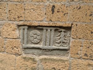 Inscrição etrusca cravada em uma parede de pedra.