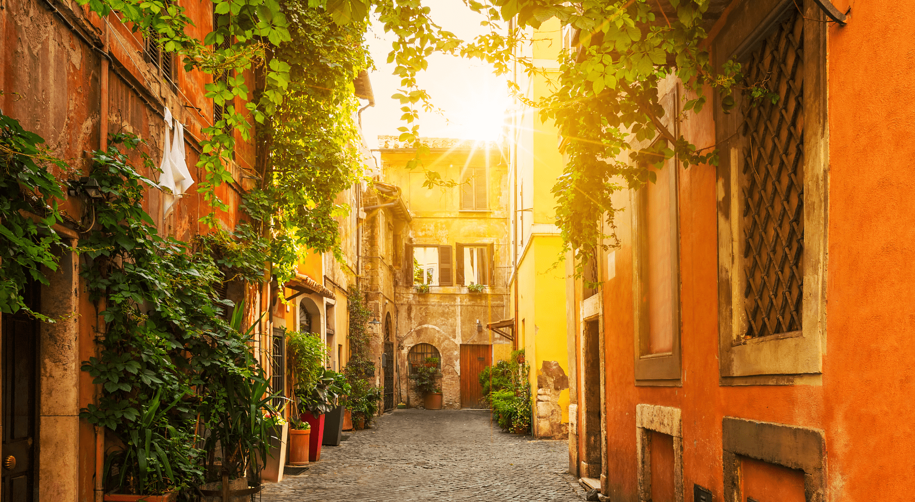 Uma ruela encantadora em Trastevere durante o dia, com o sol se pondo e banhando a cena em uma luz dourada, destacando a vegetação exuberante e a arquitetura tradicional com cores quentes