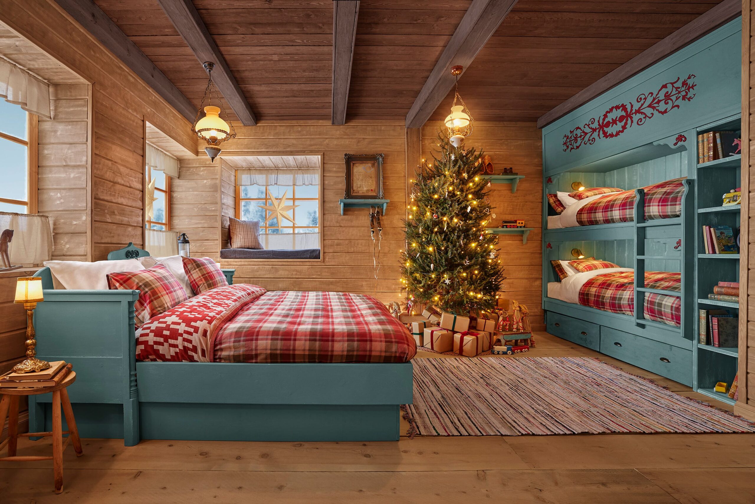 Quarto acolhedor na Cabana do Papai Noel com cama de casal e beliche, decorado com árvore de Natal e presentes.