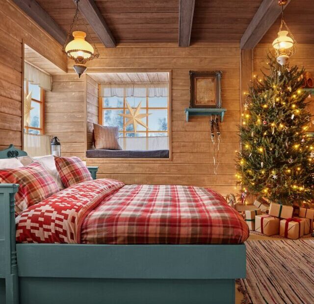 Quarto acolhedor na Casa do Papai Noel com cama de casal e beliche, decorado com árvore de Natal e presentes.