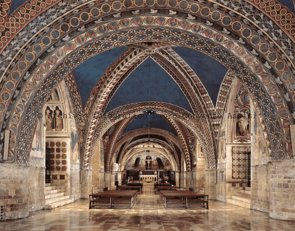 Close-up do interior da igreja menor da Basílica de São Francisco de Assis com tetos abobadados decorados com afrescos coloridos, mostrando cenas religiosas e elementos arquitetônicos góticos.